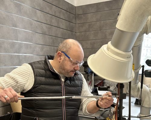 Especialista trabajando en clubmaking artesanal y personalización de palos de golf en taller profesional